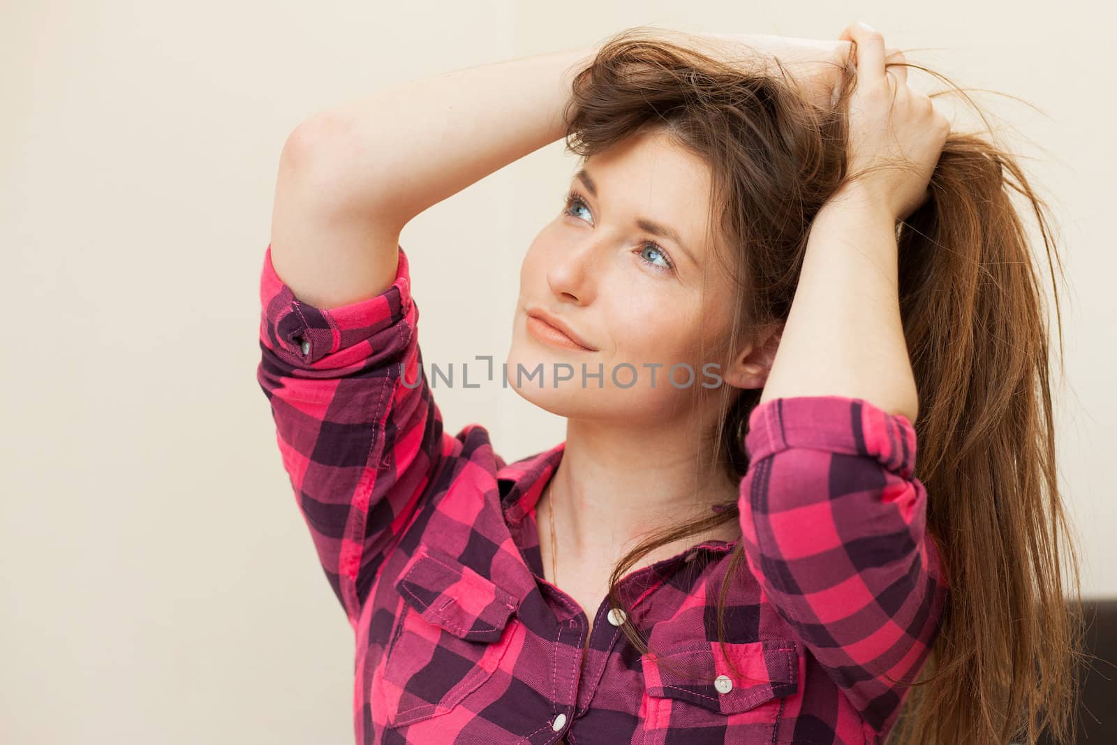 Cute young girl in casual holding her long hair in hands