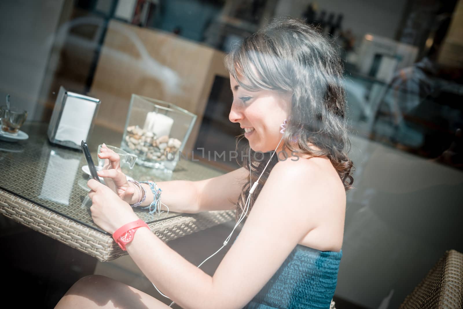 young beautiful woman listening to music at the coffee