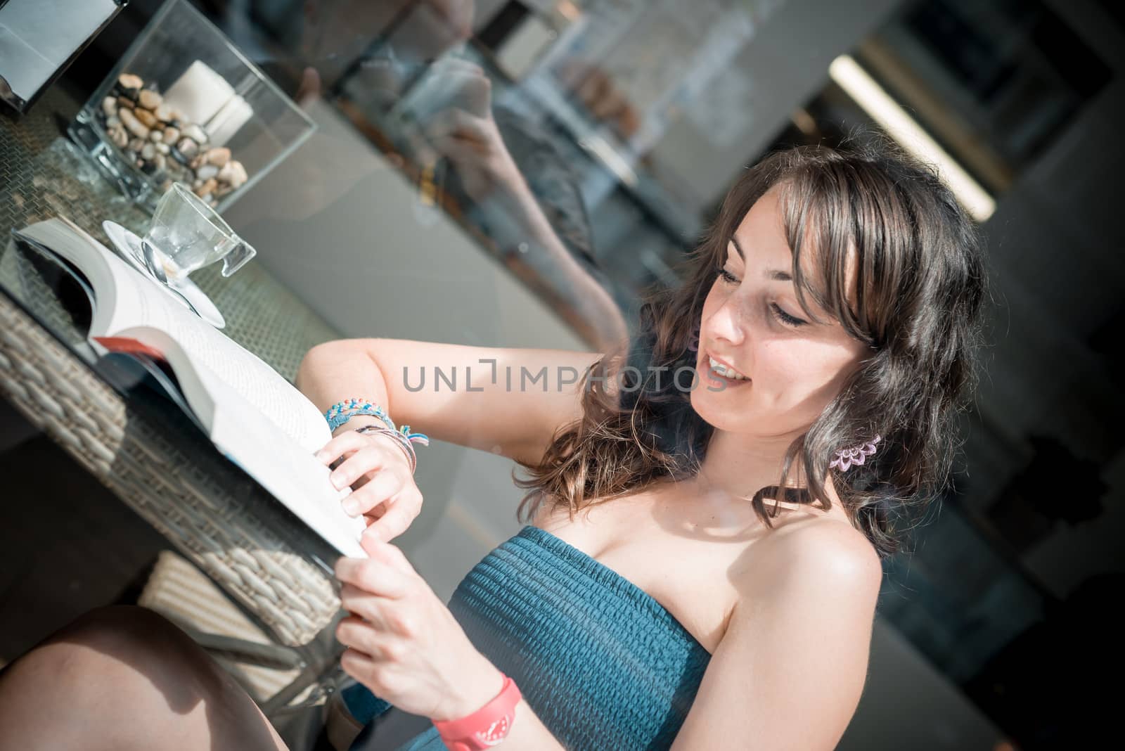 young beautiful woman reading book at the coffee