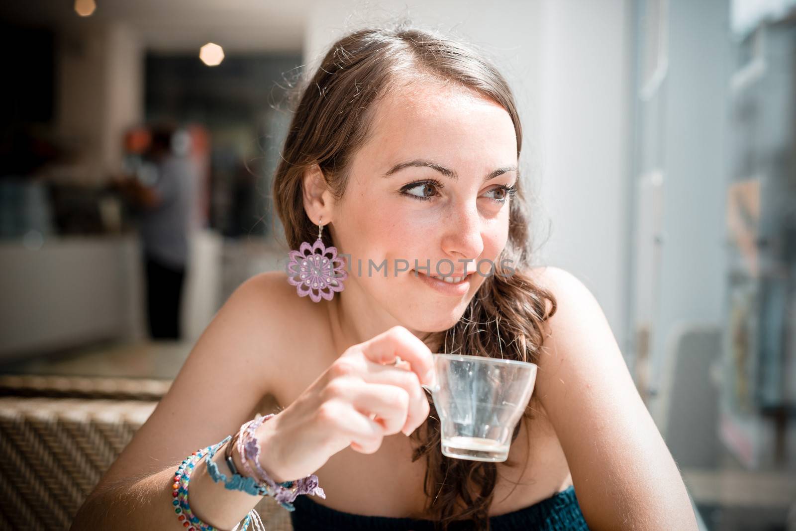 young beautiful woman drinking coffee at the coffee bar