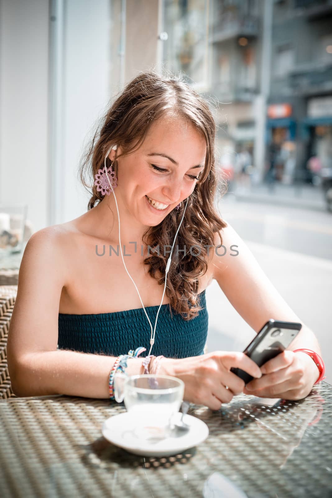 young beautiful woman listening to music at the coffee