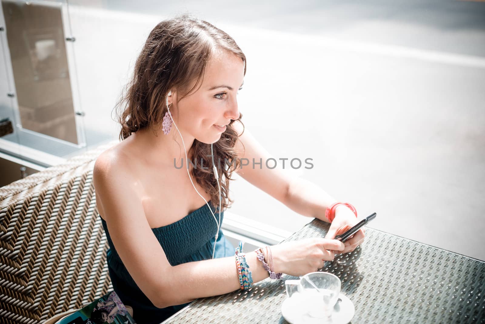 young beautiful woman listening to music at the coffee