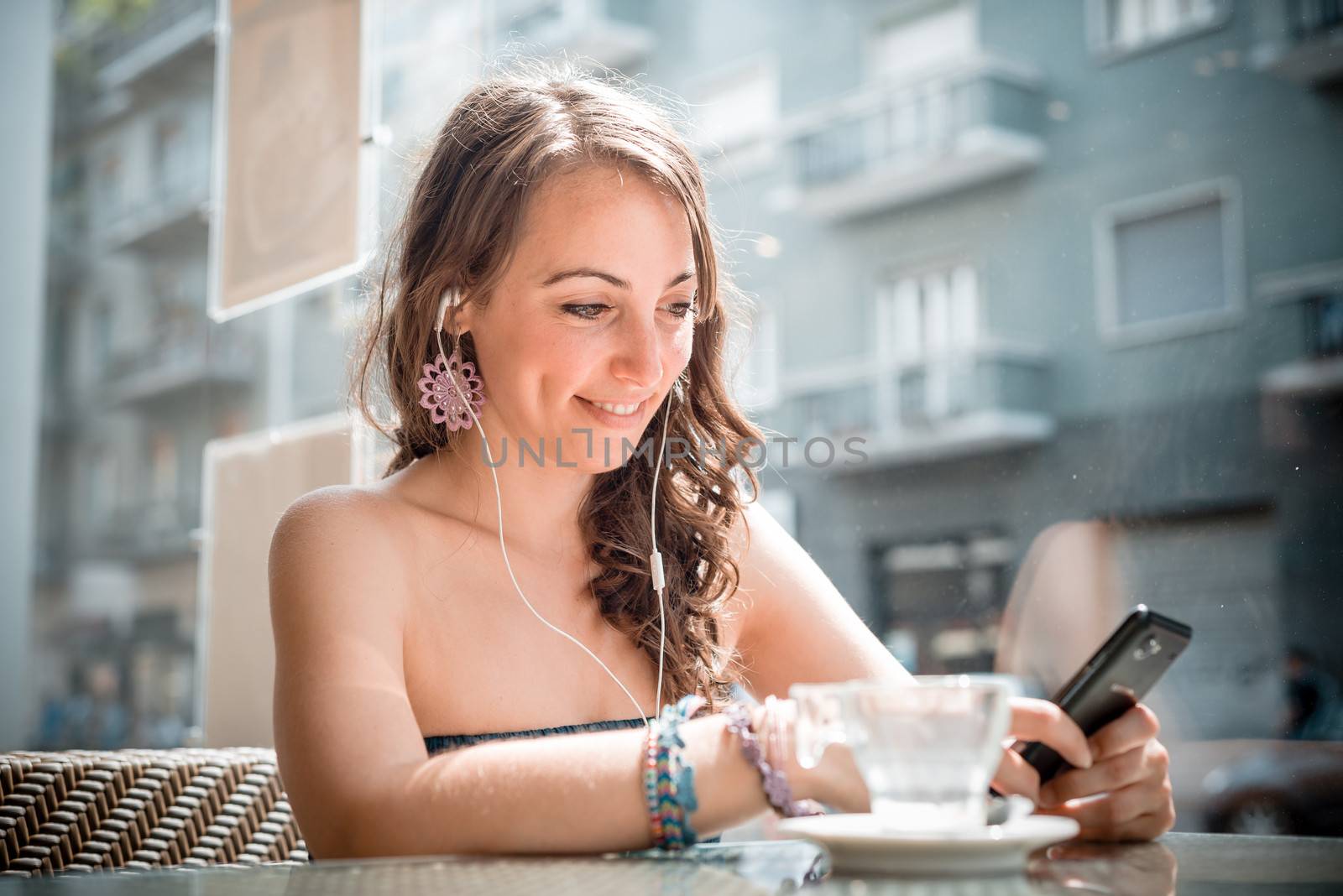 young beautiful woman listening to music at the coffee