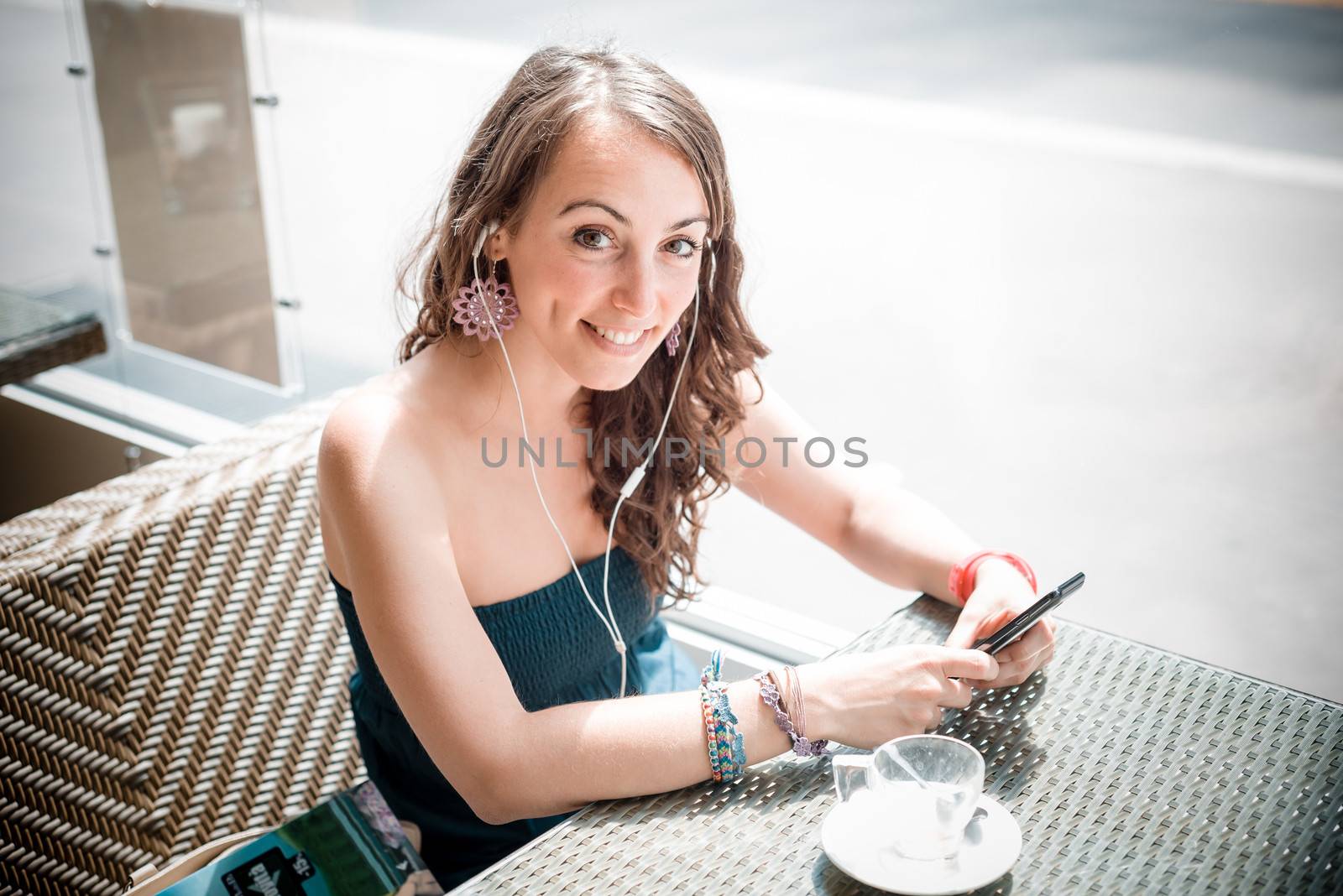 young beautiful woman listening to music at the coffee