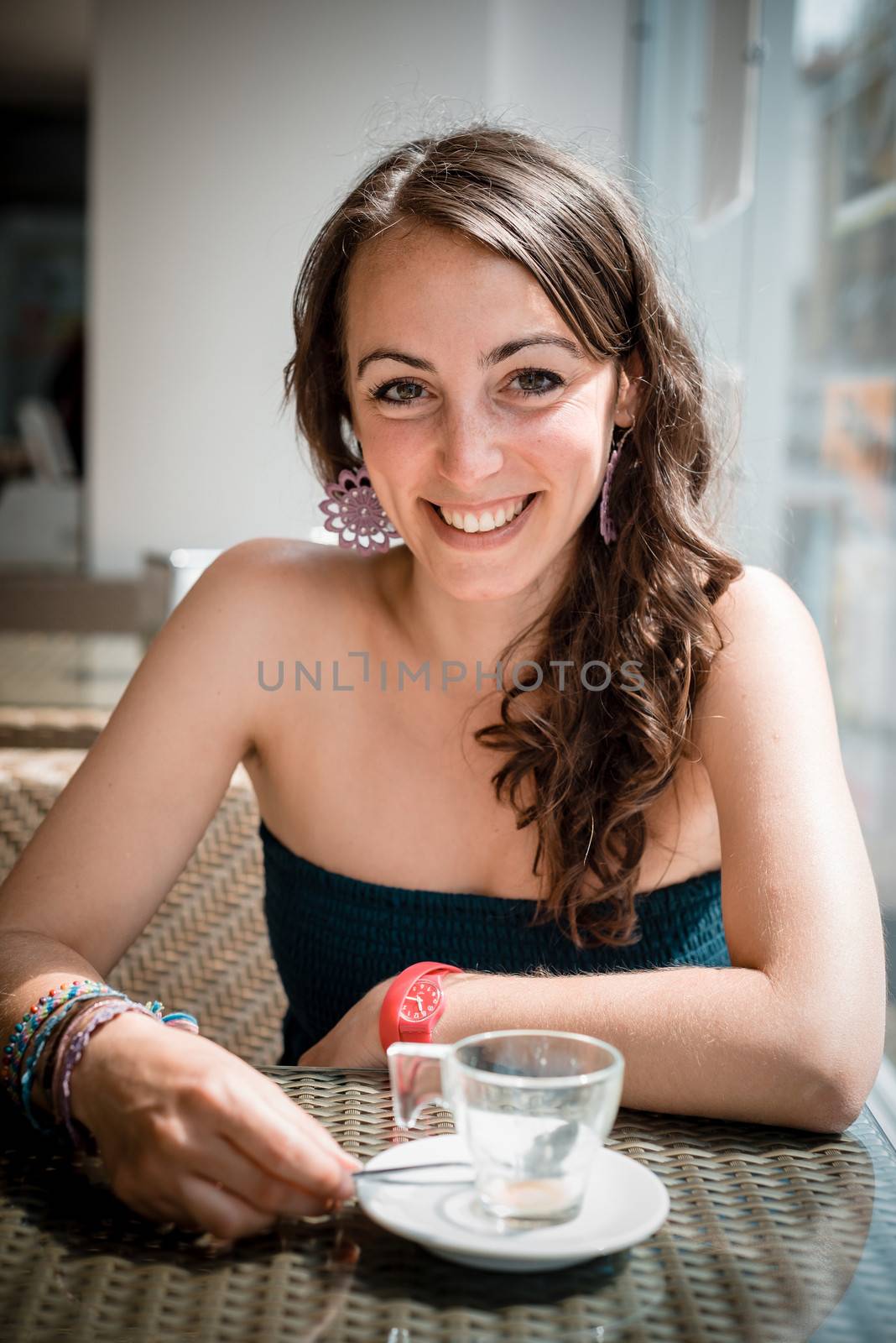 young beautiful woman drinking coffee at the coffee bar