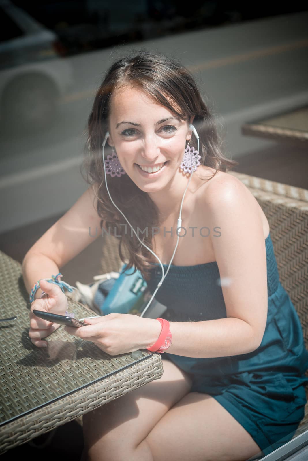 young beautiful woman listening to music at the coffee