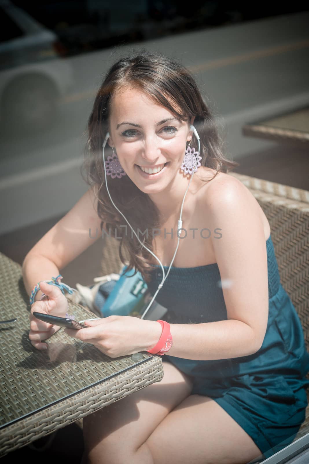 young beautiful woman listening to music by peus