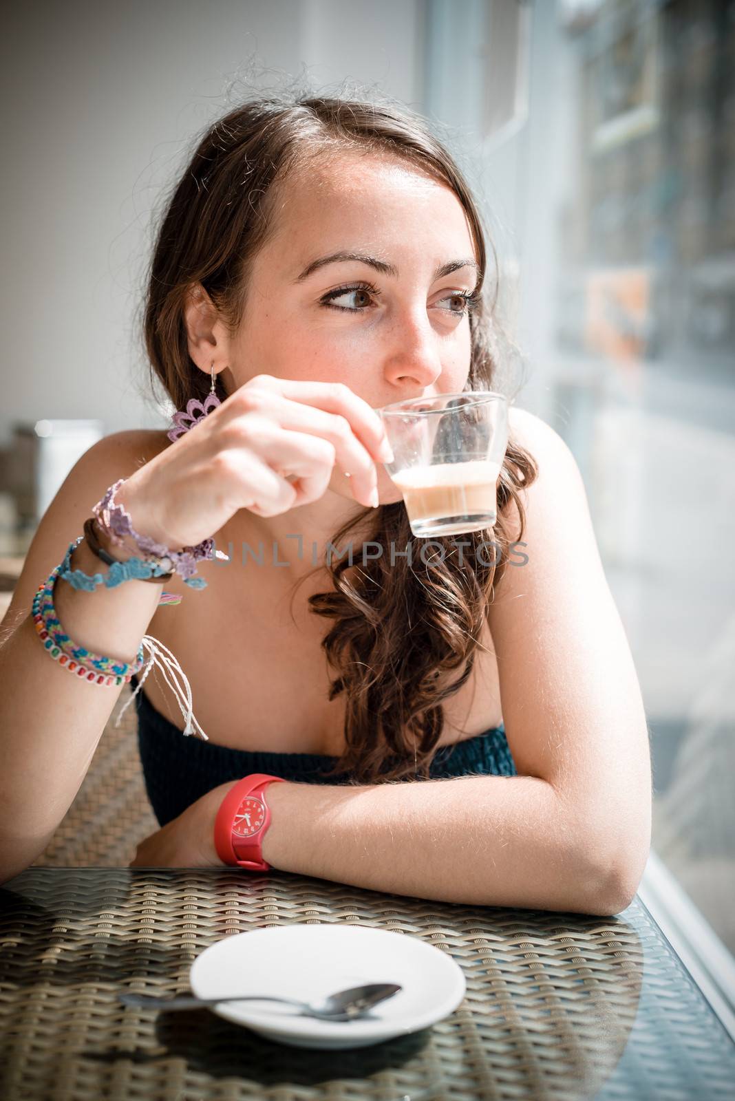 young beautiful woman drinking coffee at the coffee bar