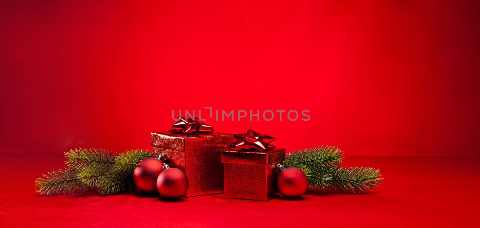 Red bauble and present in red Christmas setting