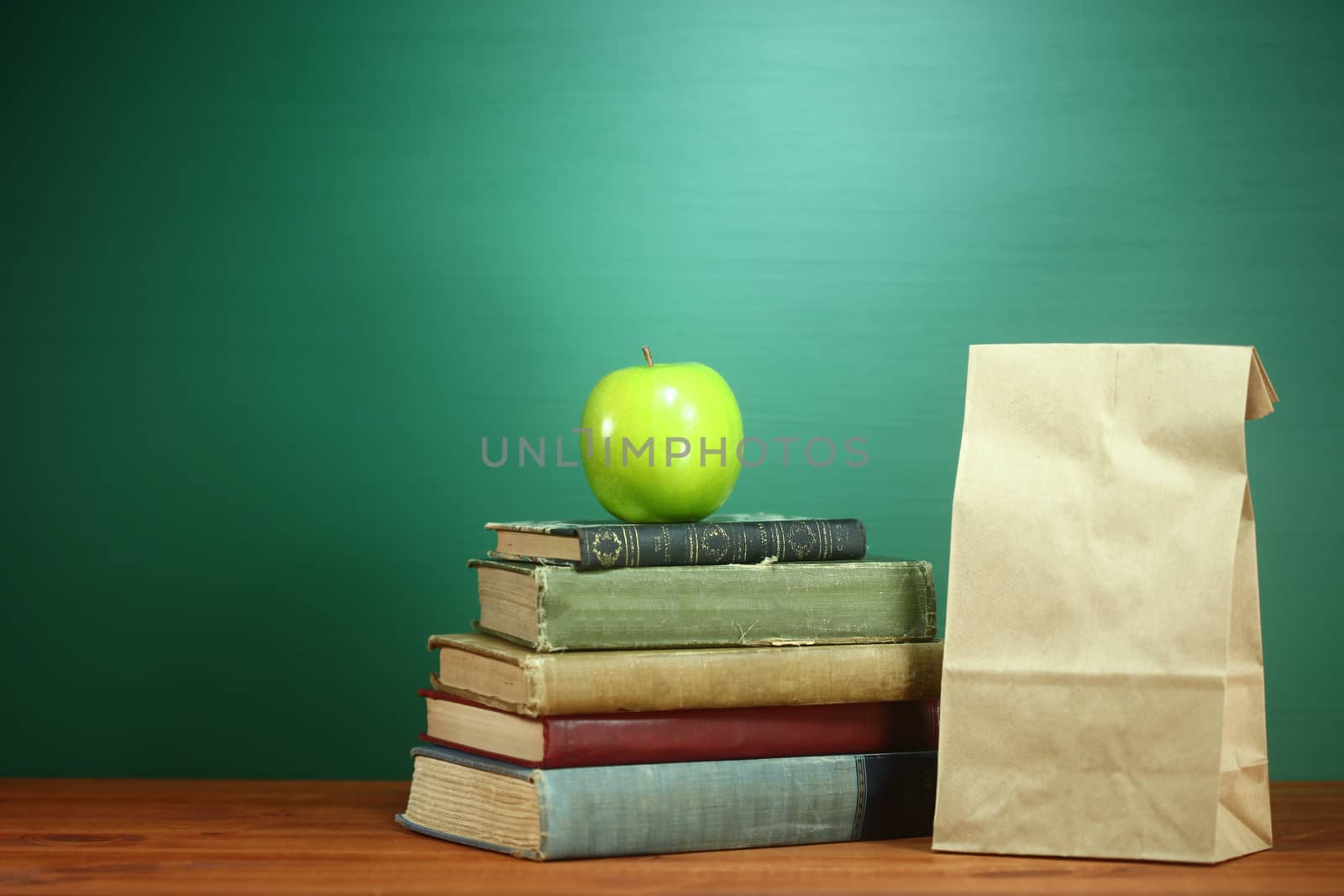 Books, Apple and Lunch on Teacher Desk by tobkatrina