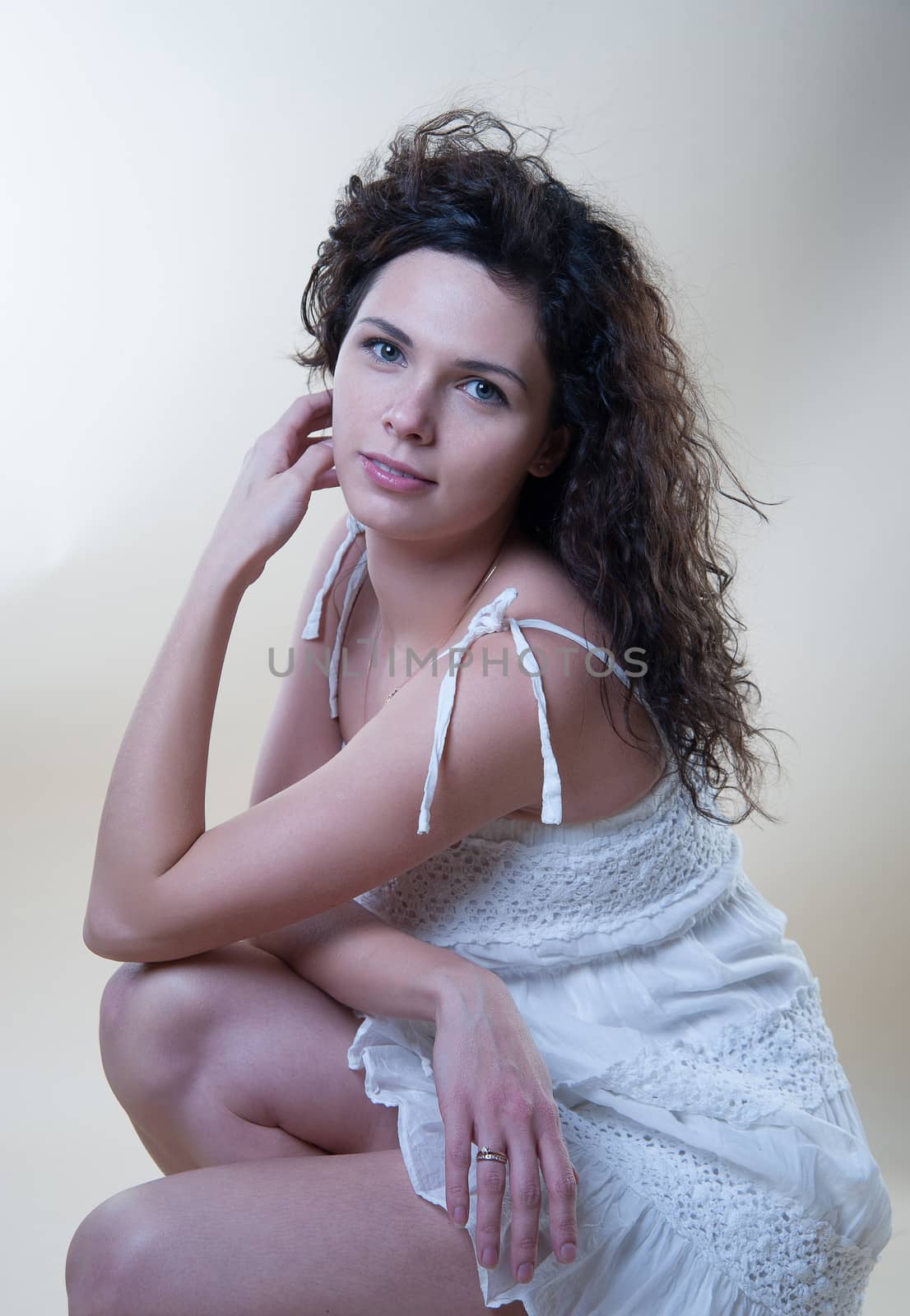 Sensual woman in a white sundress in the studio