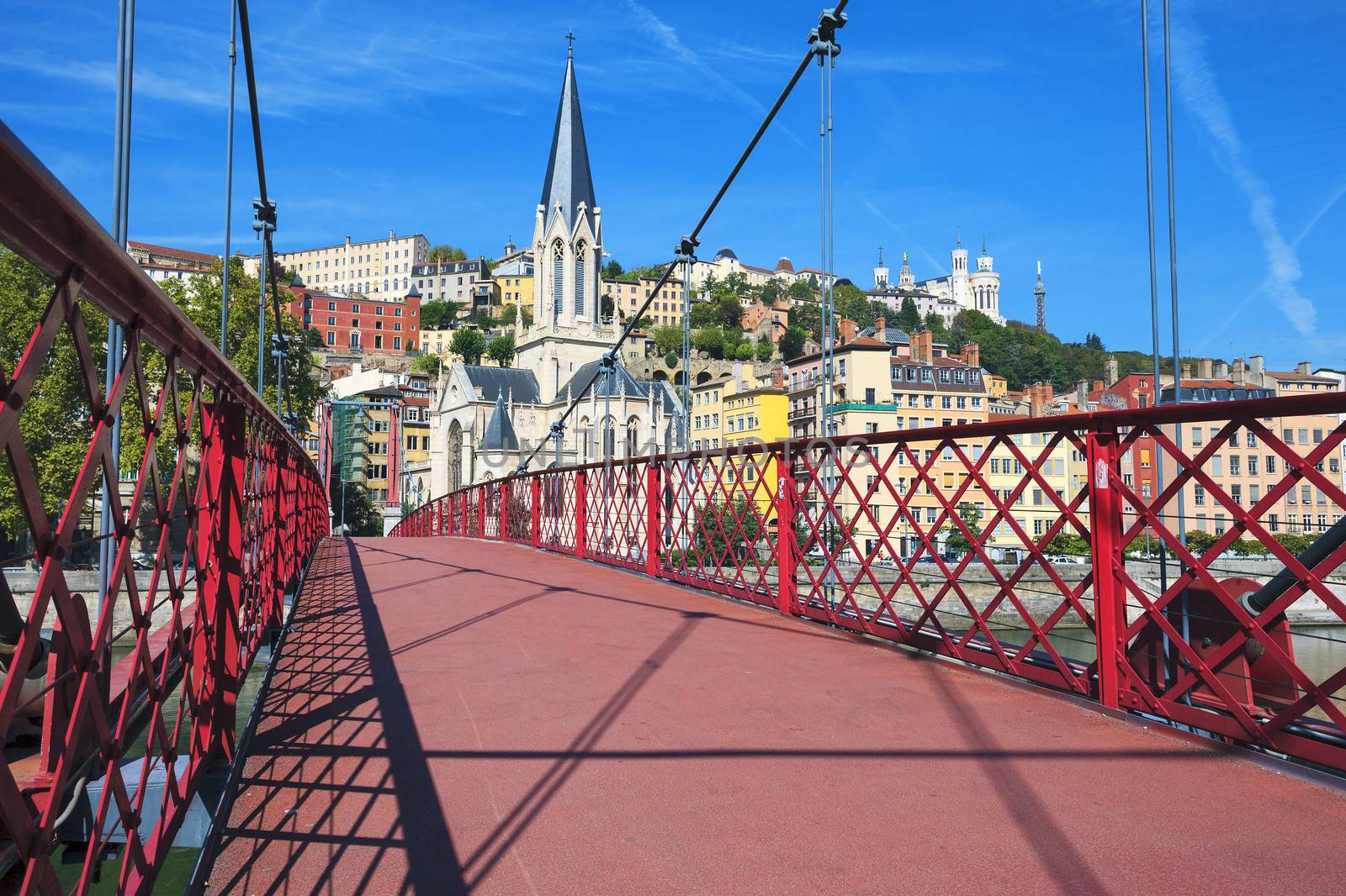 View of Lyon city with red footbridge on Saone river and church 