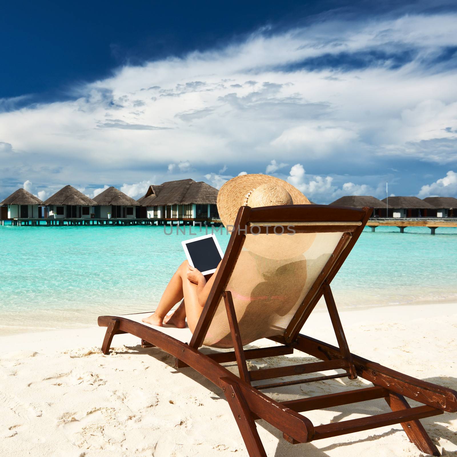 Young woman with tablet pc at the beach by haveseen