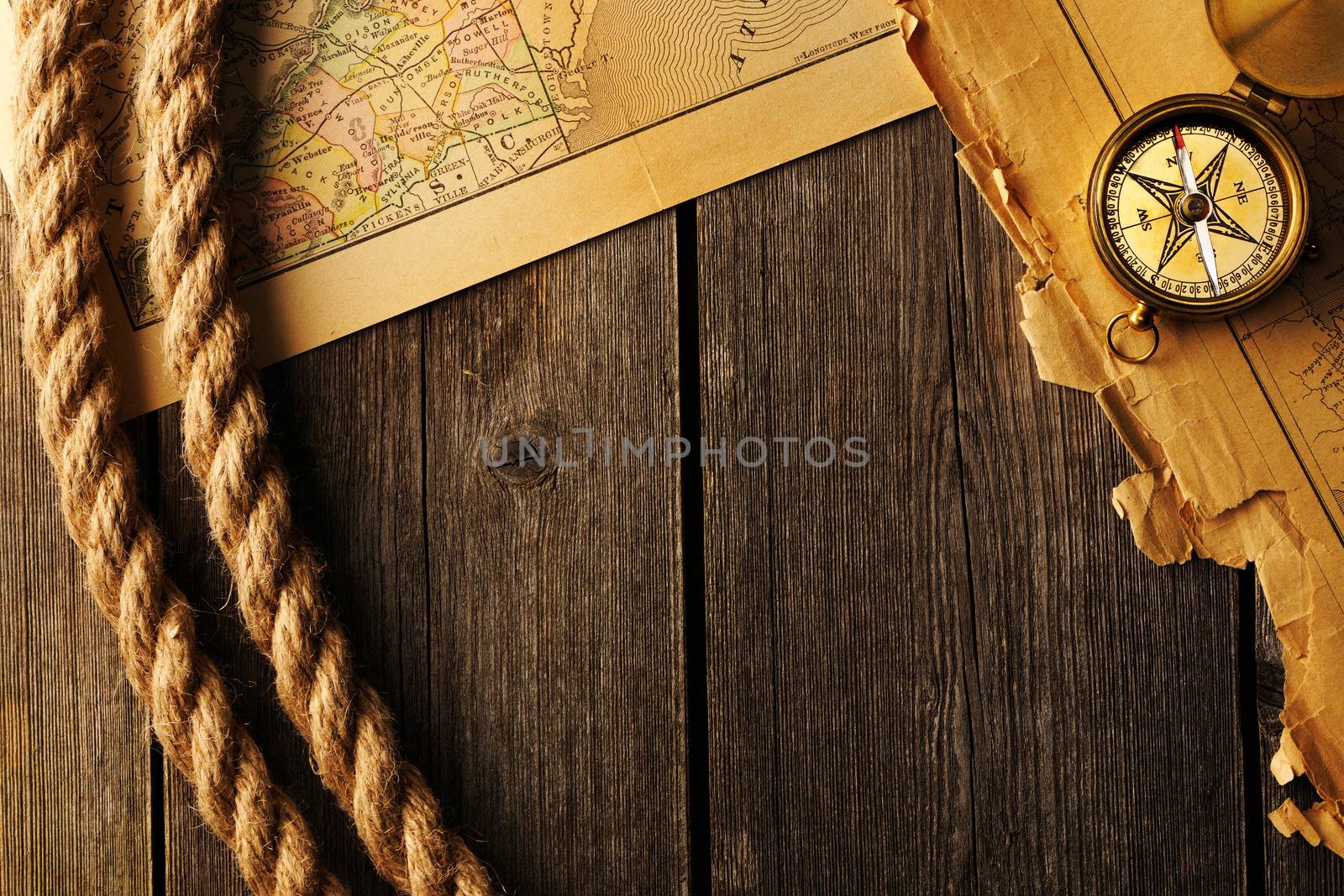 Antique brass compass and rope over old map