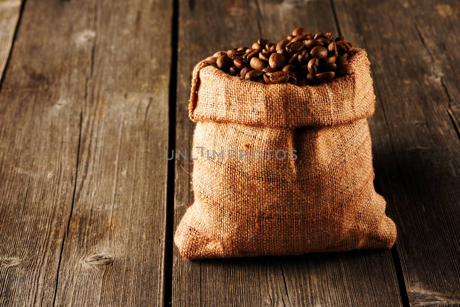 Coffee beans in bag on wooden table
