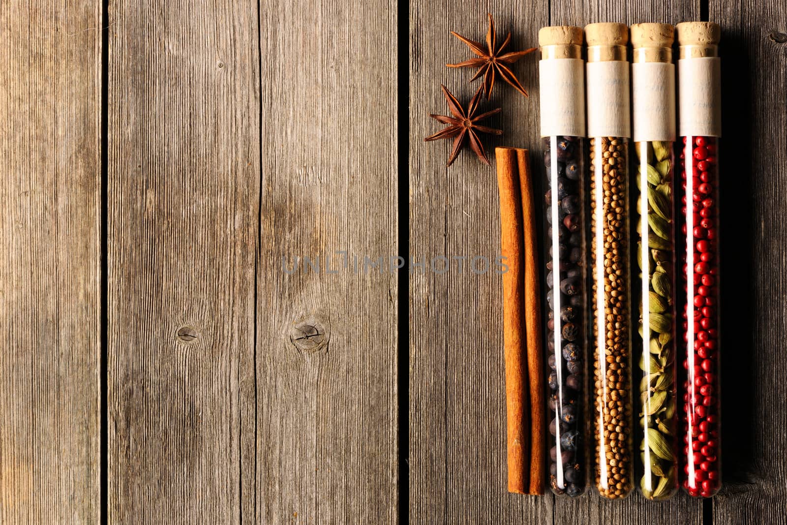 Spices in beakers on wooden background