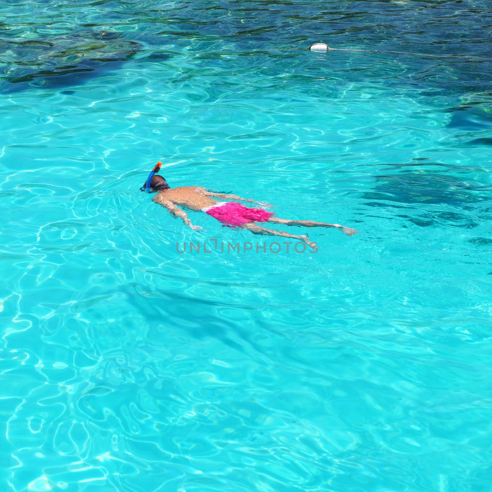 Man snorkeling in crystal clear turquoise water at tropical beach