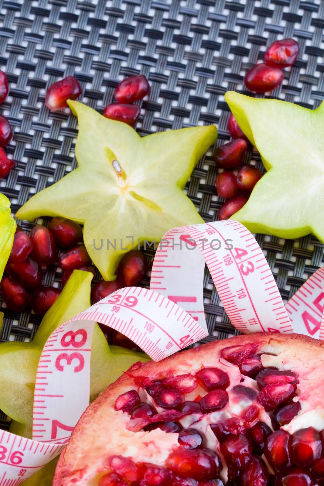 Fresh pomegranate and carambola fruits with tailor tape