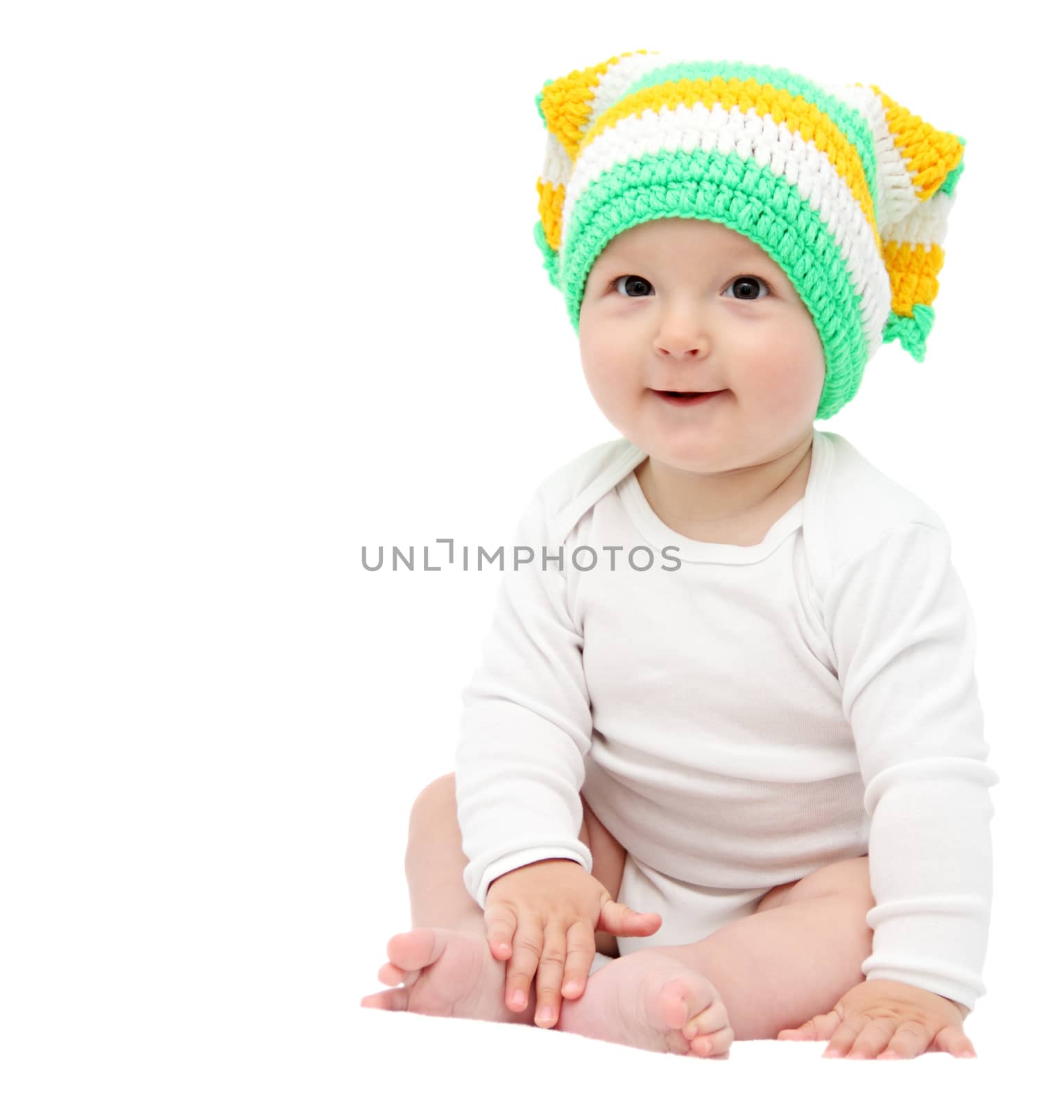 beautiful happy baby boy sitting on white bed