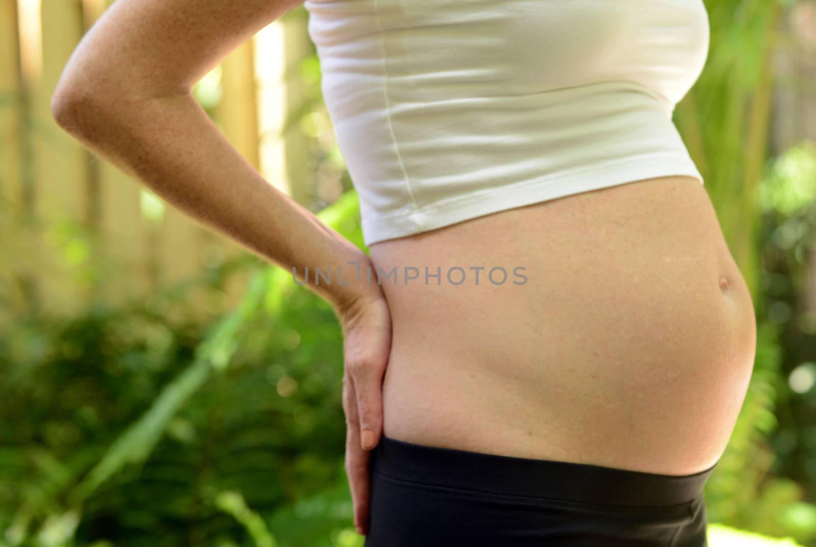 woman holding back to signify back pain while pregnant