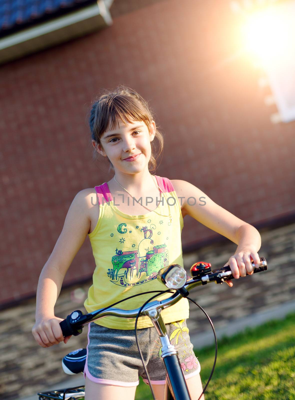 Girl on a bicycle against the brick wall at house by vladimir_sklyarov