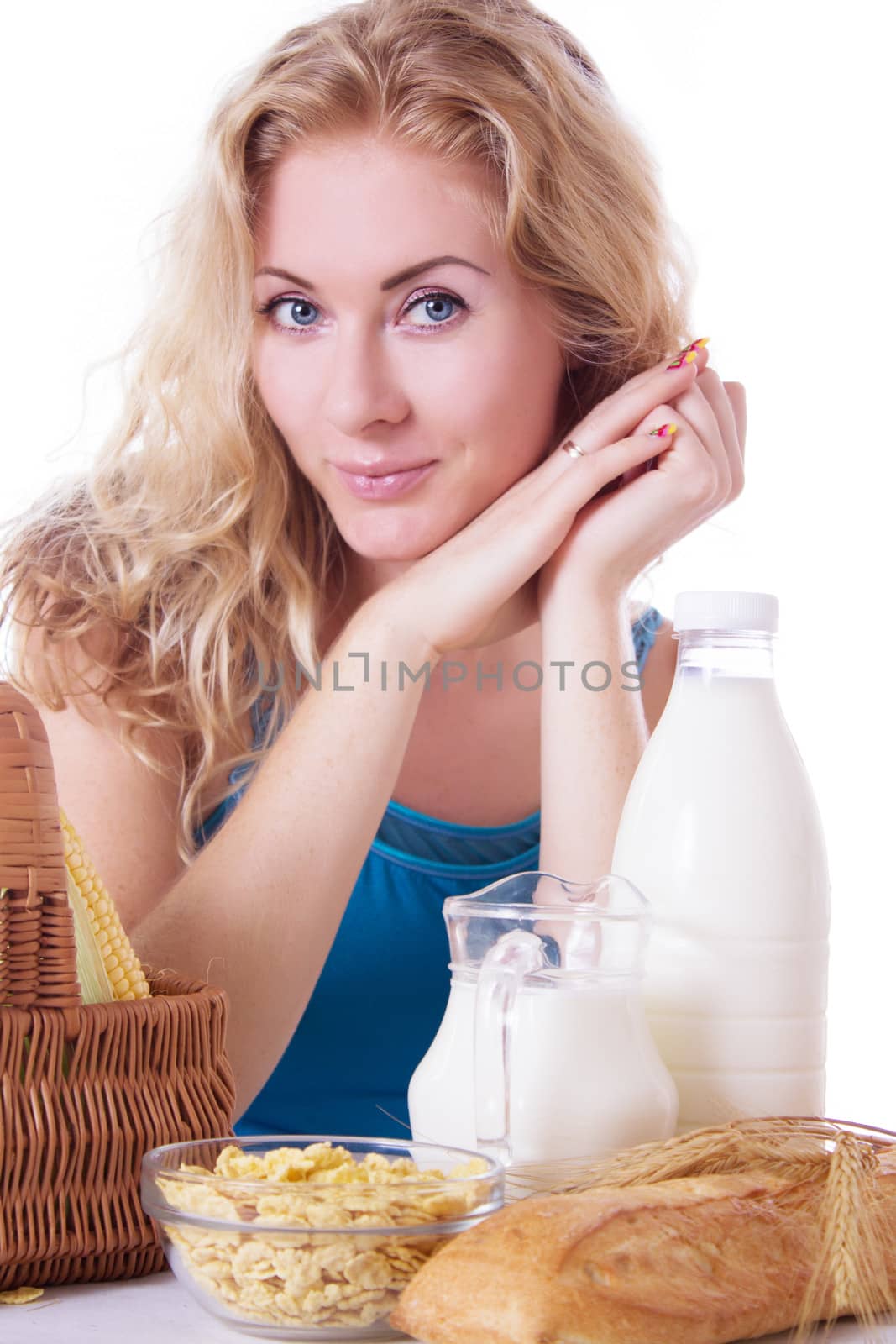 Pretty woman with milk and corn-flakes at table by Angel_a