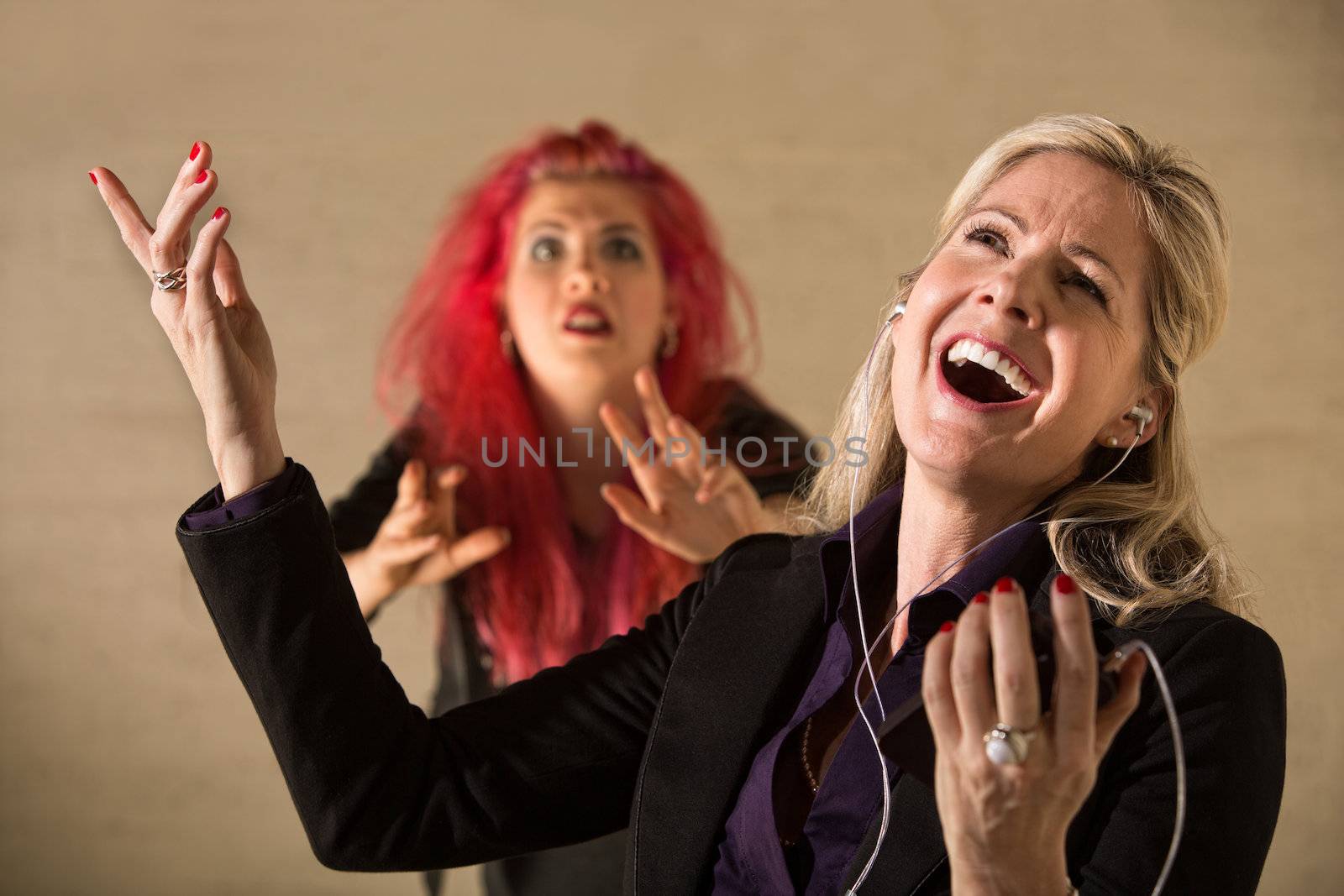 Embarrassed teen in pink hair with singing parent holding mp3 device