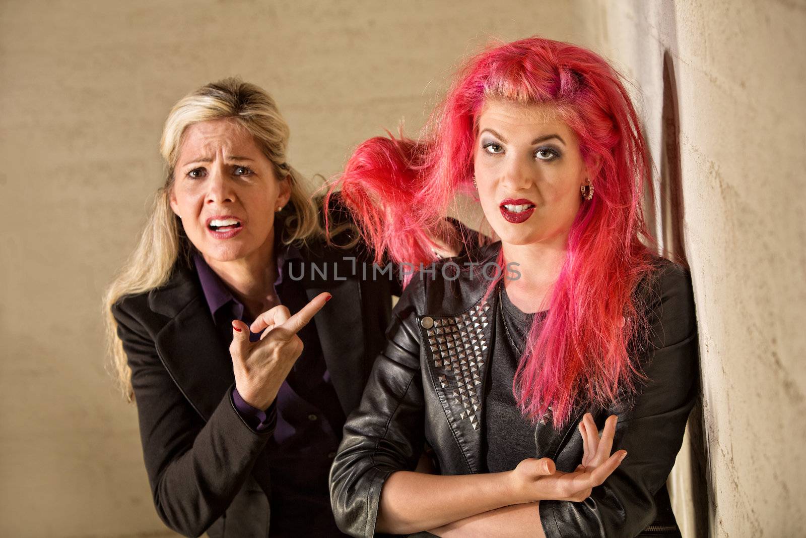 Upset mother holding teenage girls pink hair