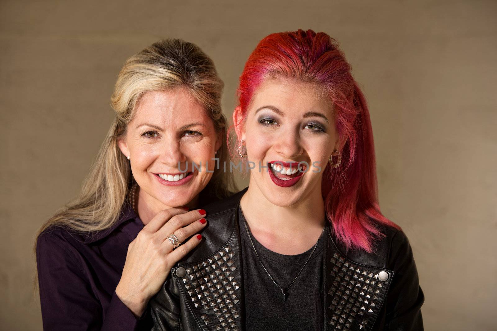 Laughing beautiful European mother and daughter indoors