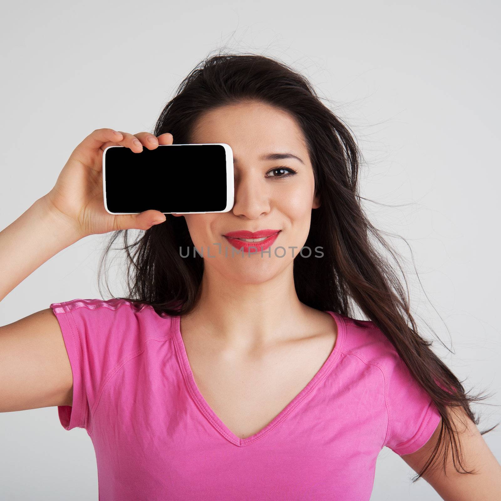 Beautiful woman in pink t-shirt shows the phone