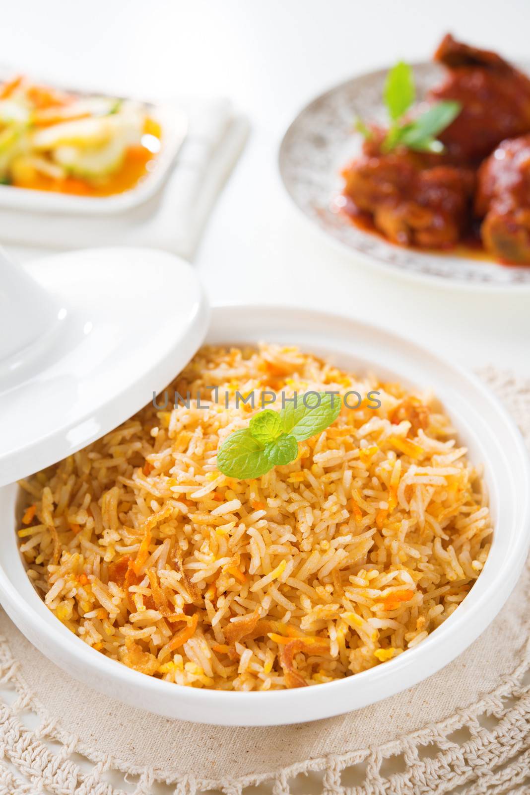 Biryani rice or briyani rice, curry chicken and salad, traditional indian food on dining table.