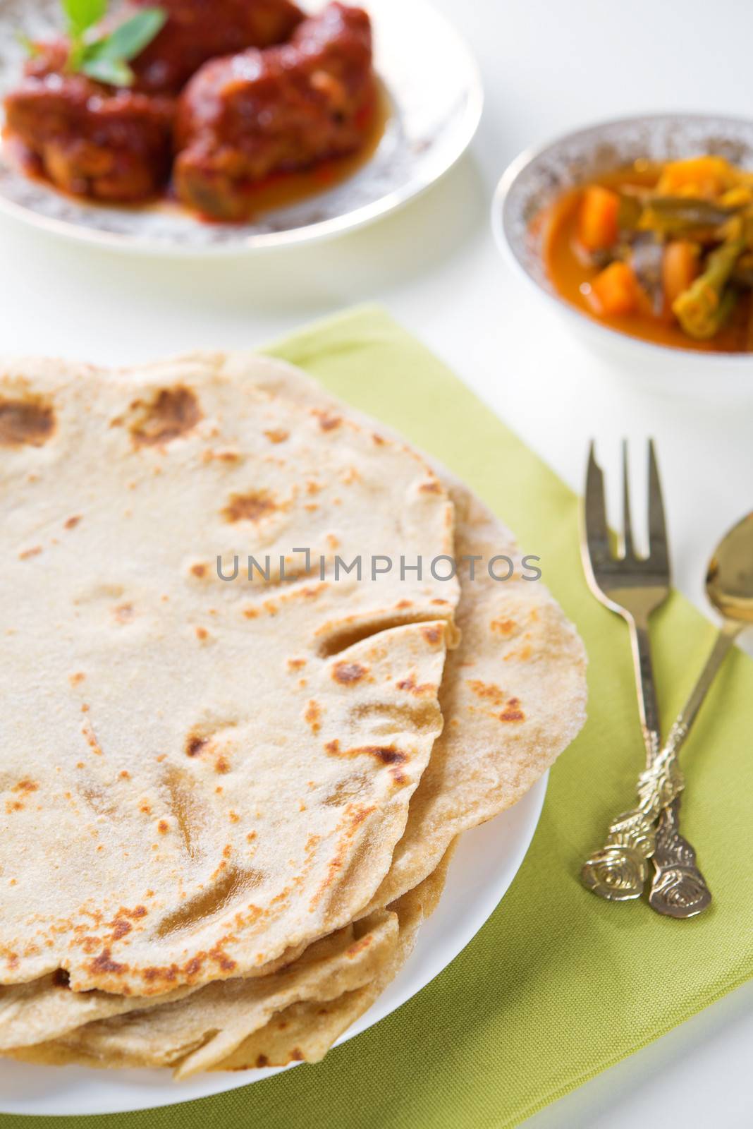 Chapatti roti or Flat bread, curry chicken and dhal. Indian food on dining table. 