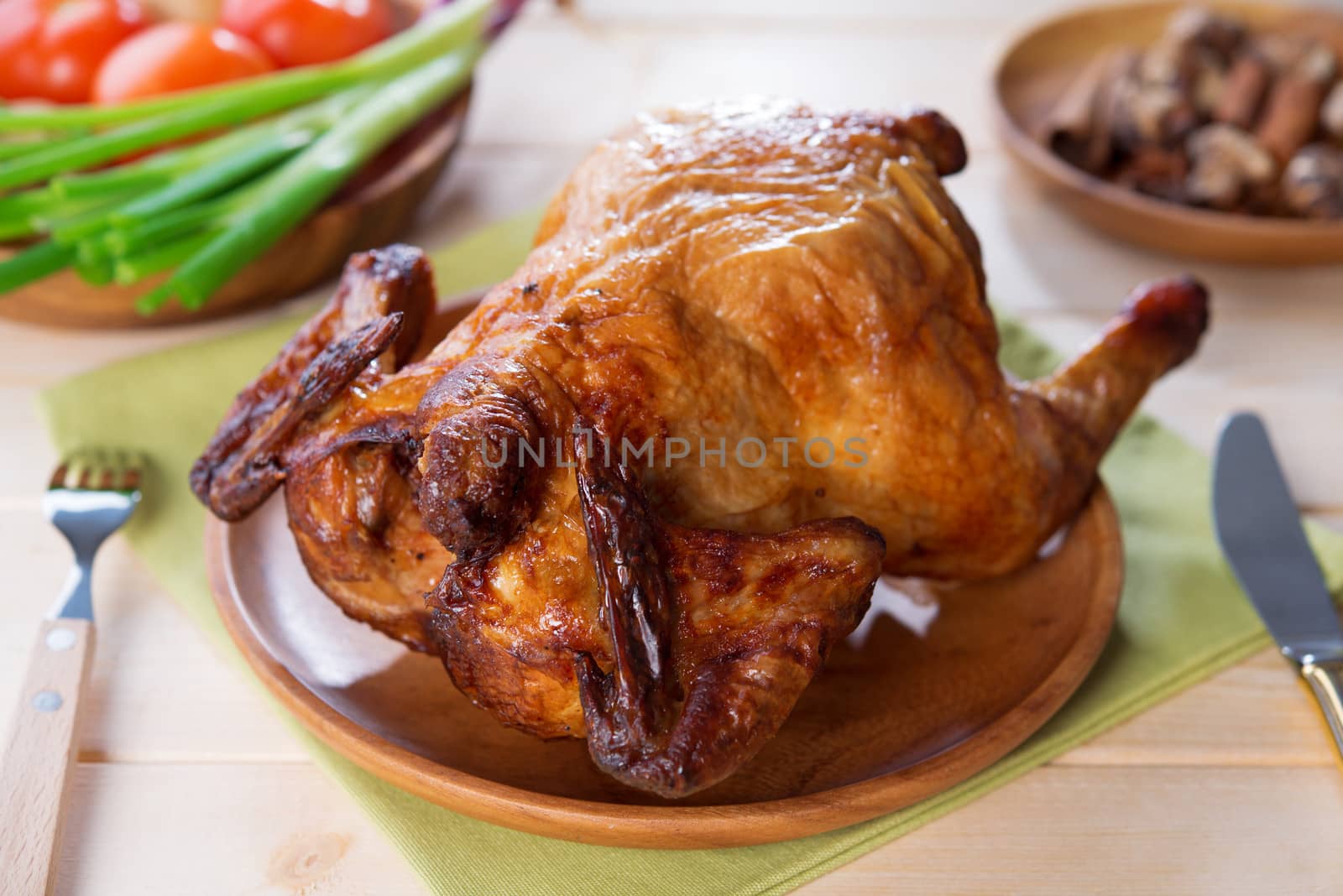 Whole roast chicken ready to eat on dining table.