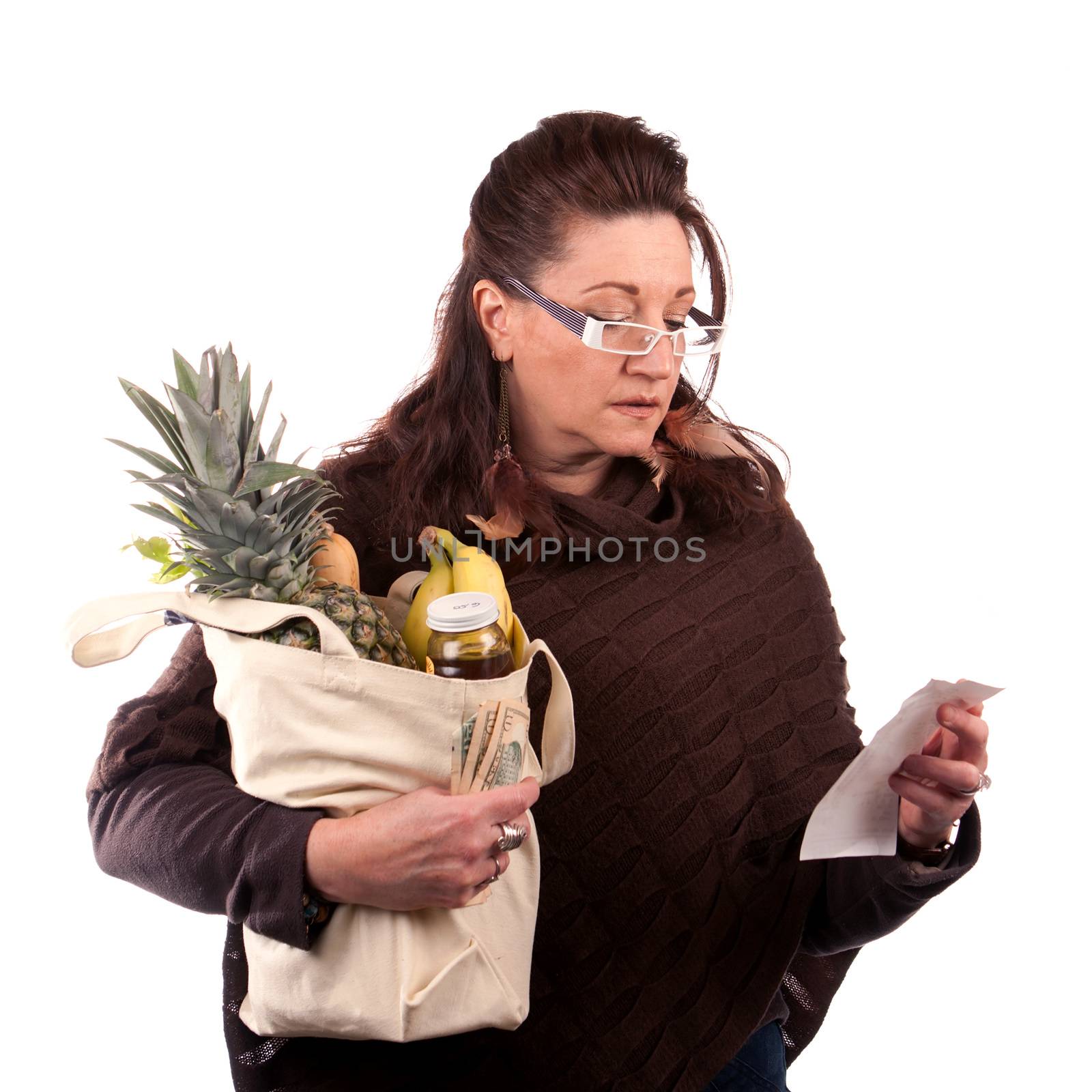 Middle aged woman carefully examining her register receipt reviewing her grocery shopping bill.