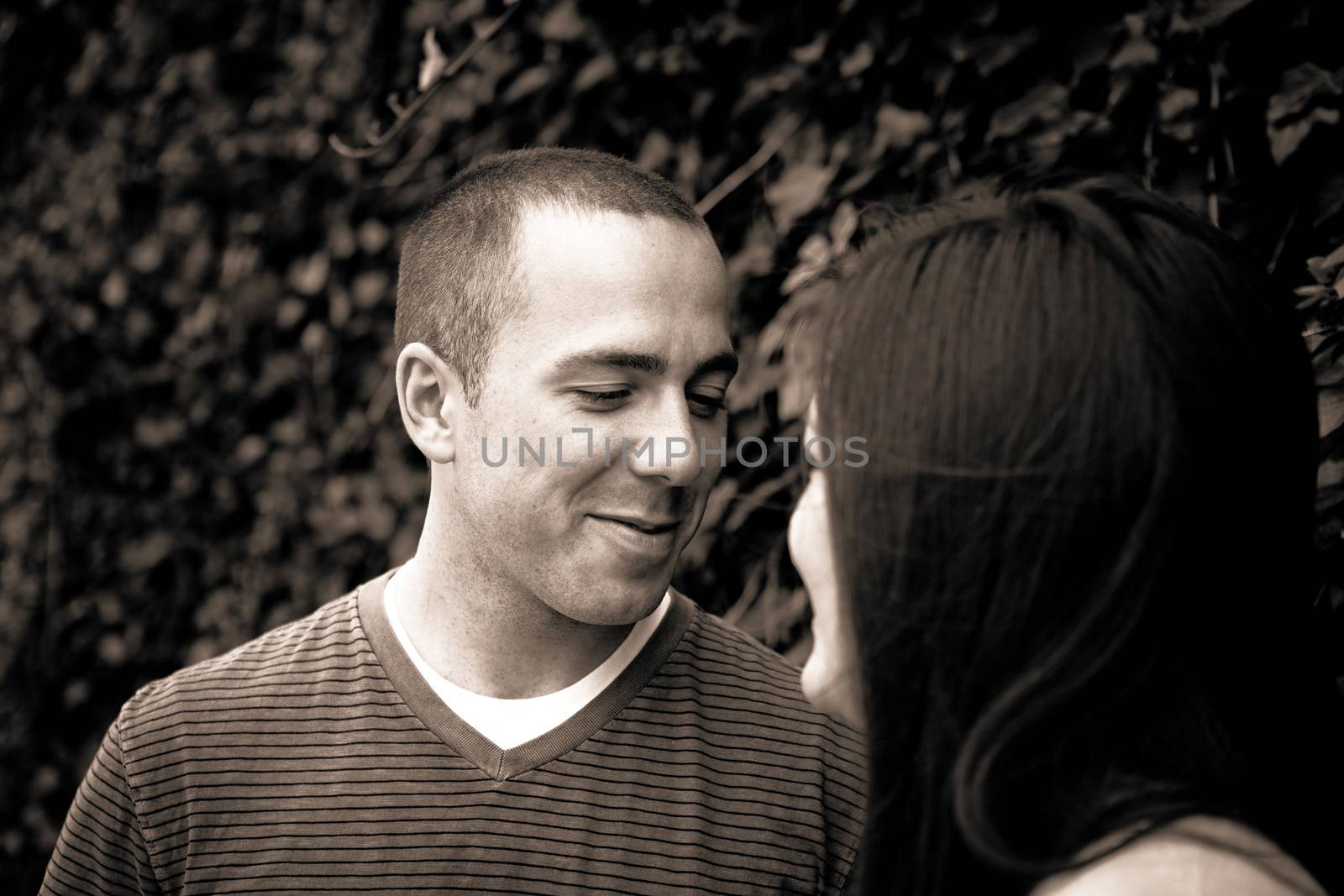 Young happy couple enjoying each others company outdoors. Sepia tone.