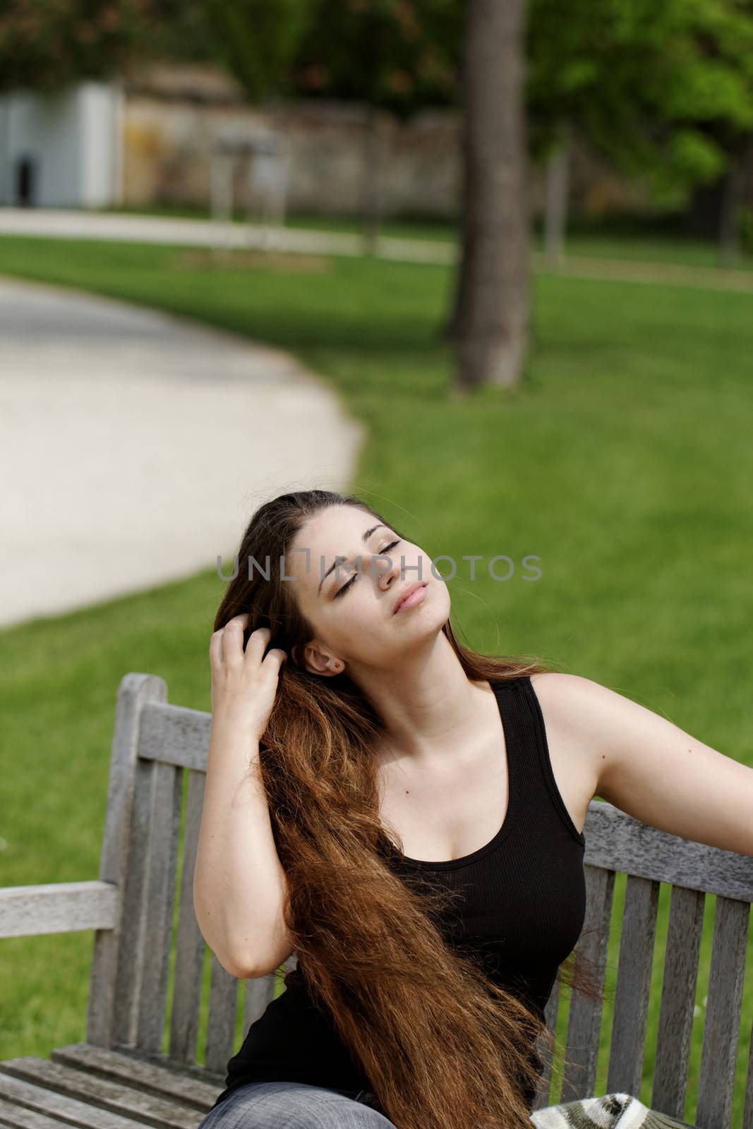pretty young girl sunbathing on a bench