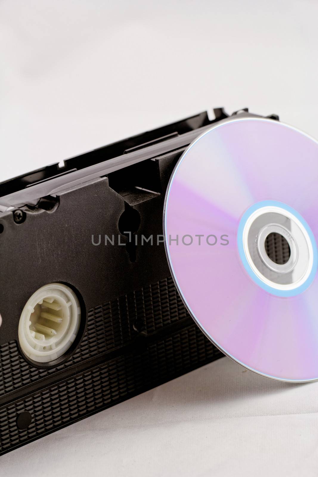 VHS video tape and DVD disk (analog digital) on white background