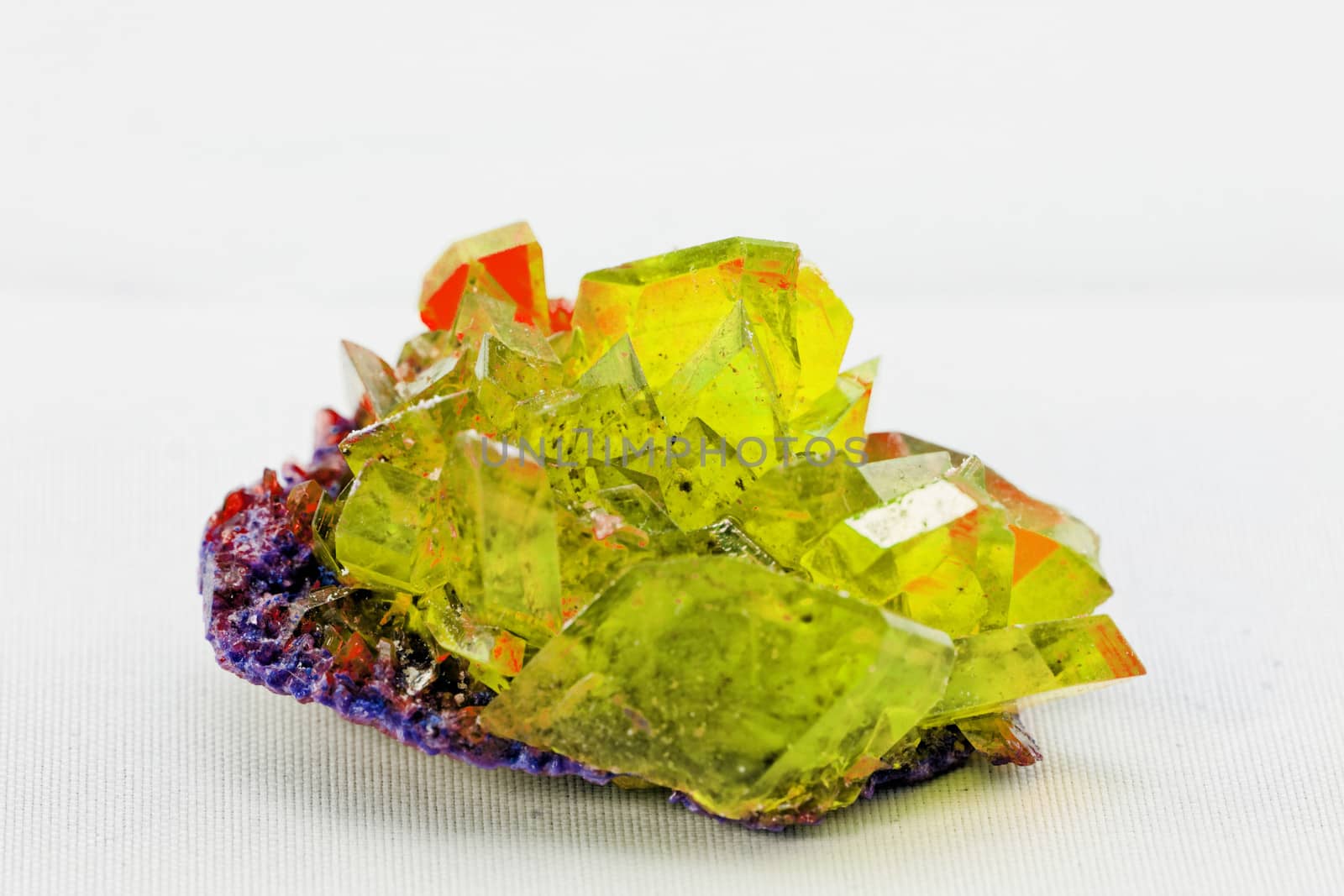 Close up picture about a crystal with topaz color on white background (yellow crystal)