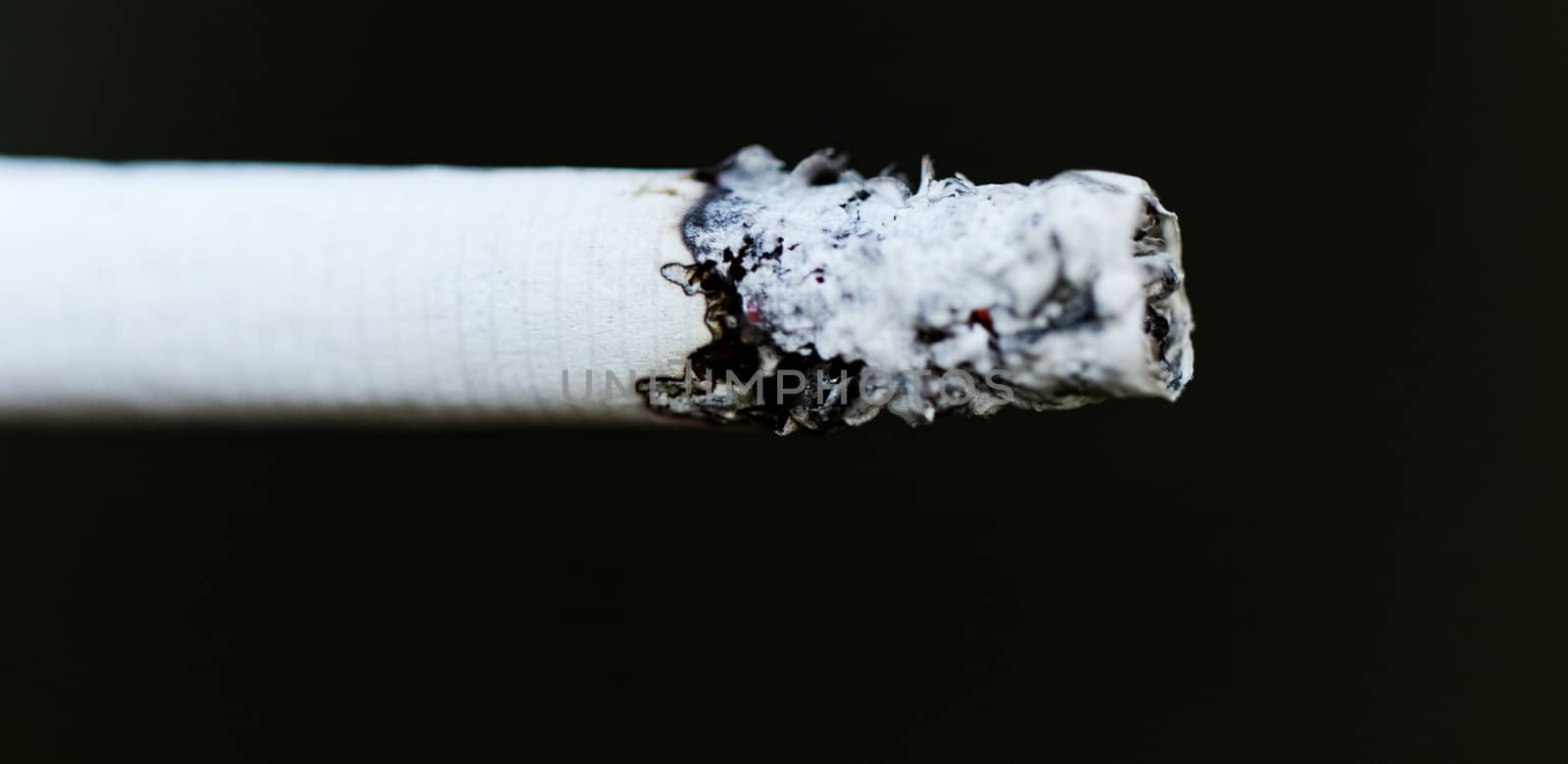 Smoking a cigarette against a dark background