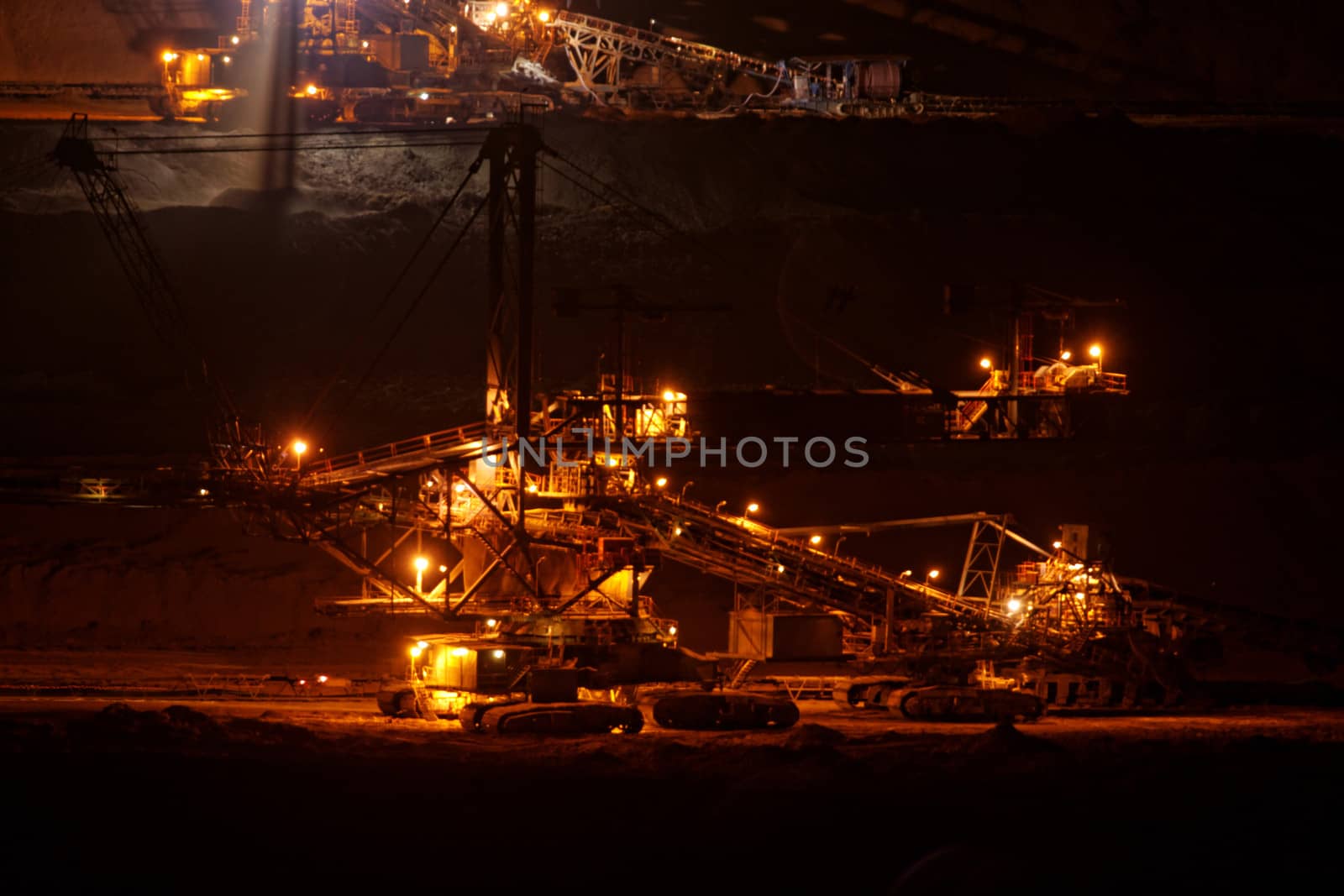 Coal mining in an open pit with huge industrial machine at night shoot