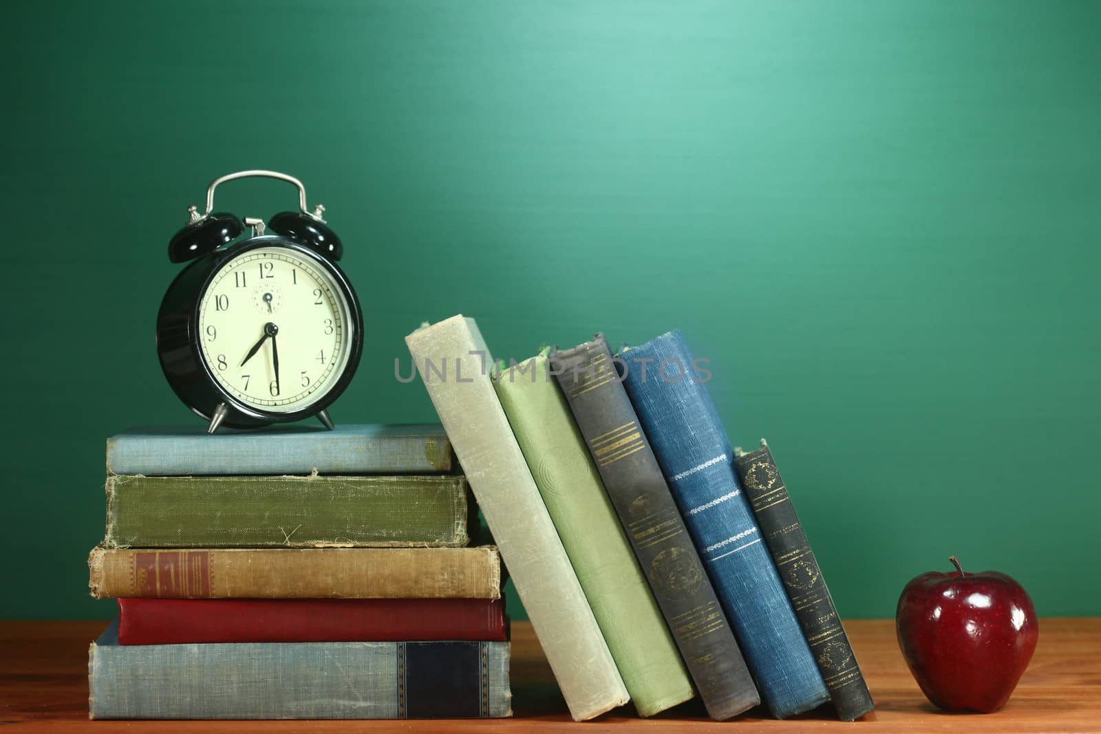 School Books, Apple and Clock on Desk at School by tobkatrina