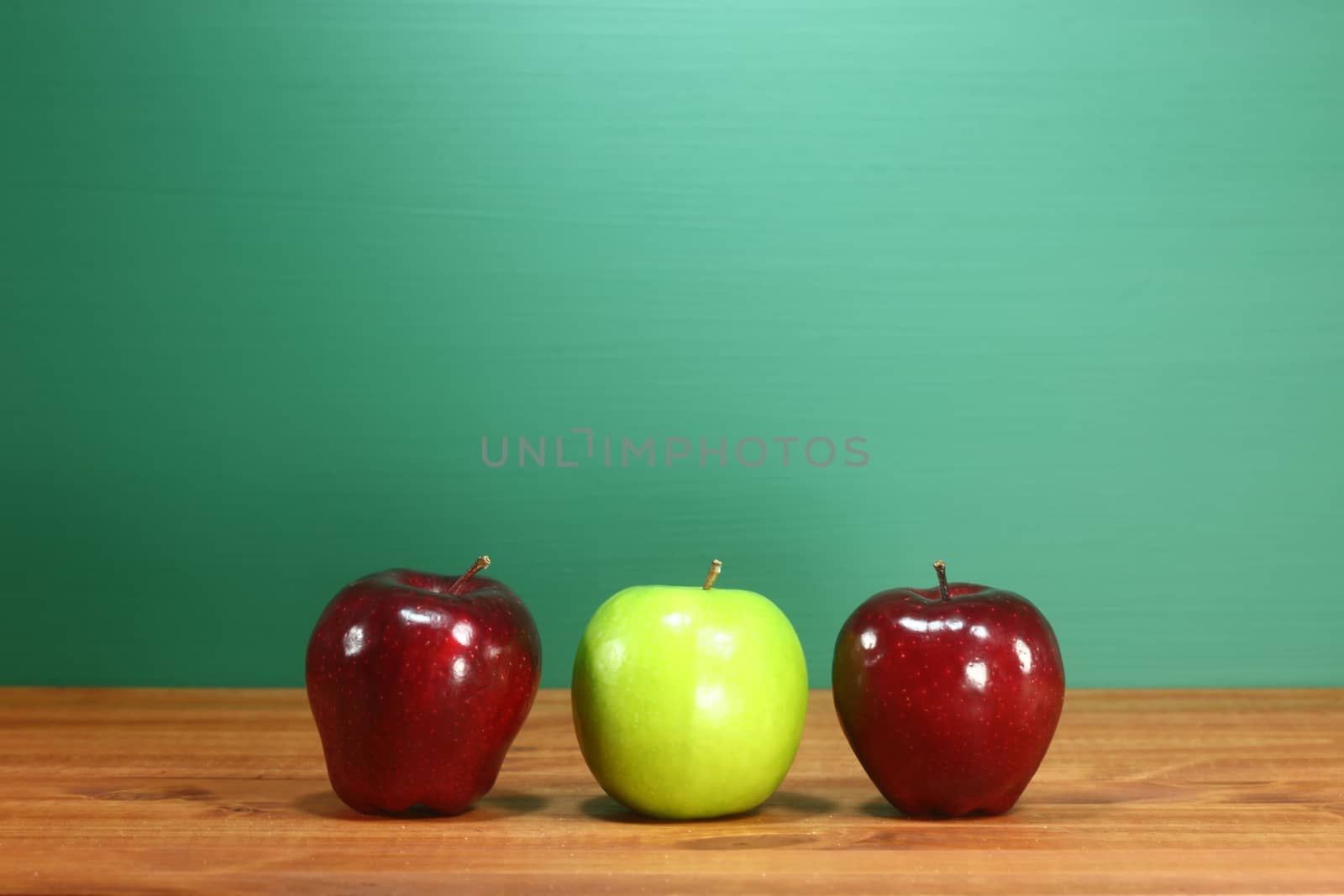 School Apples Sitting on Teacher Desk in a Row by tobkatrina