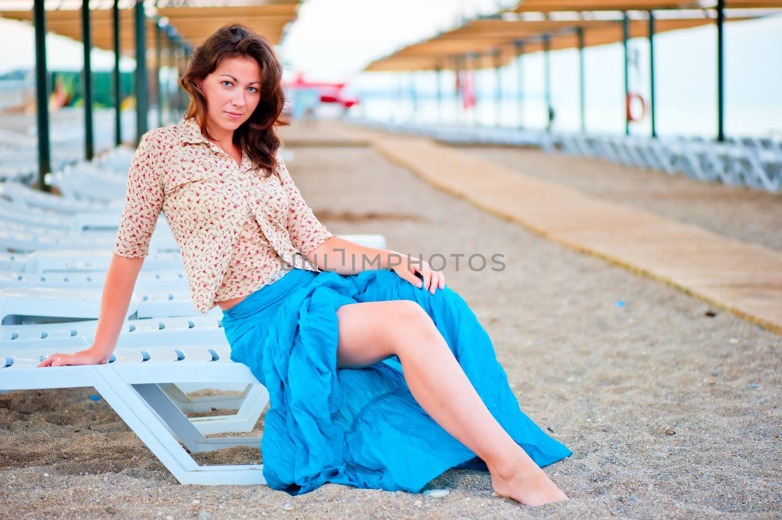 Beautiful young girl posing on a beach lounger