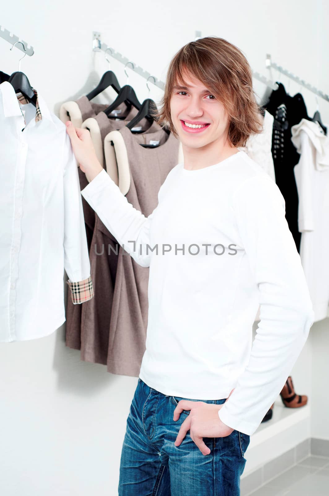 man in shop of clothes, smiles and is happy with purchases