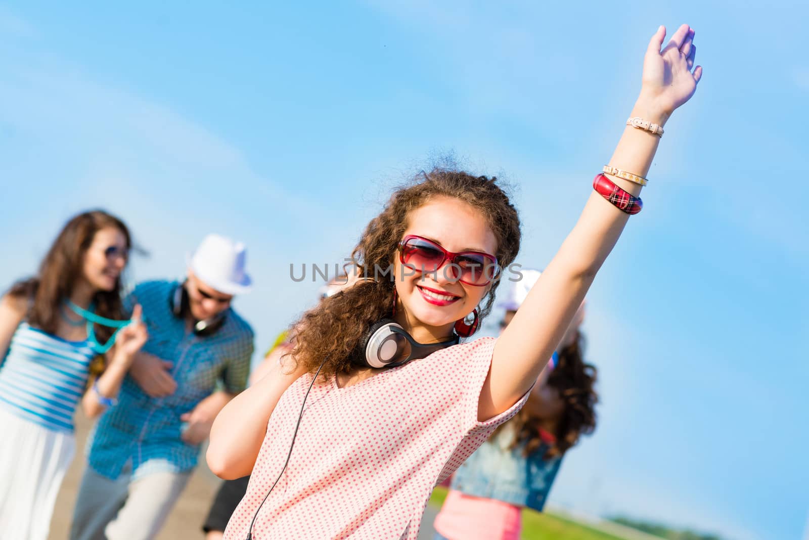 young woman with headphones on a background of blue sky and funny friends