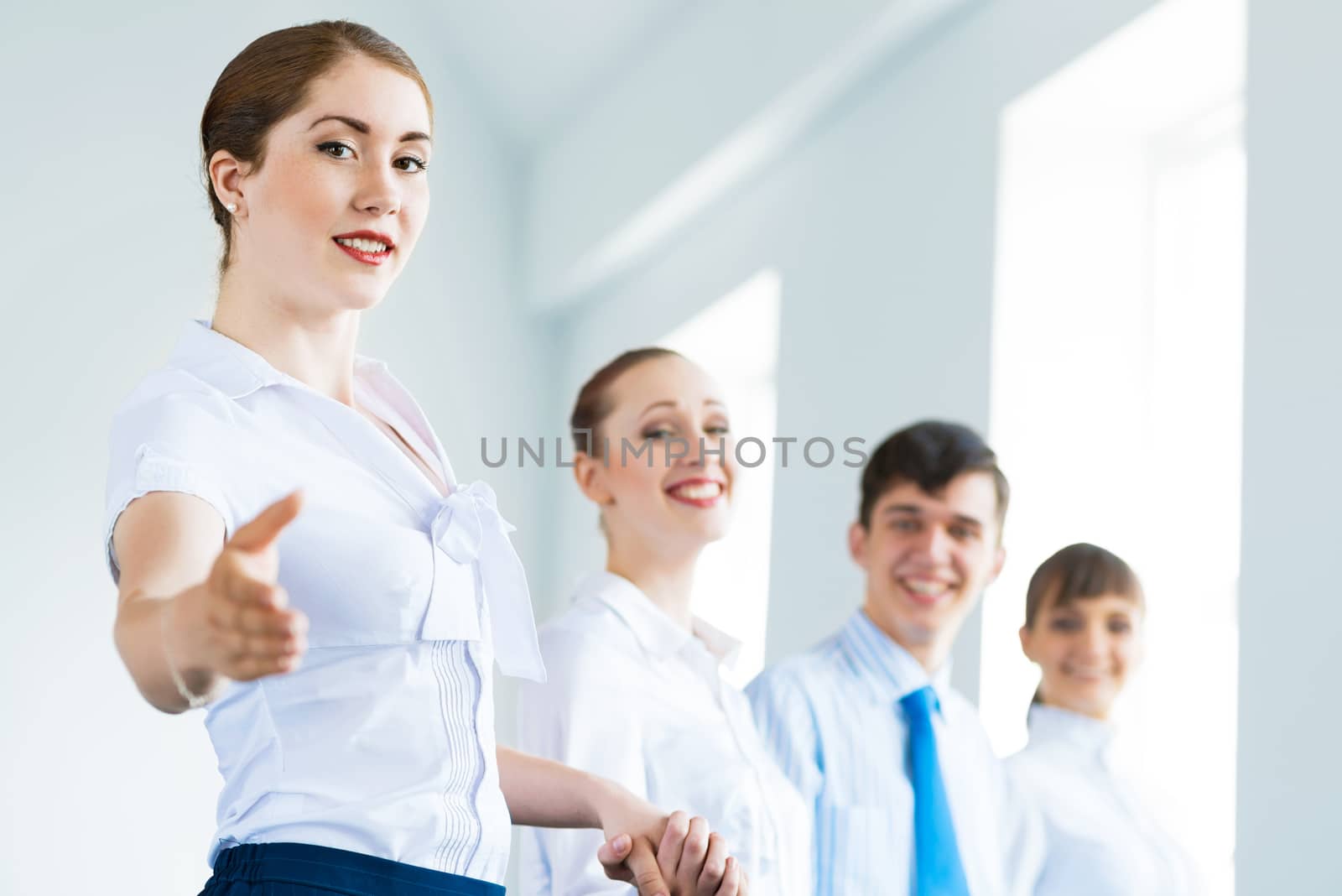 invitation to the team, business woman holds out her hand, her face a number of young businessmen