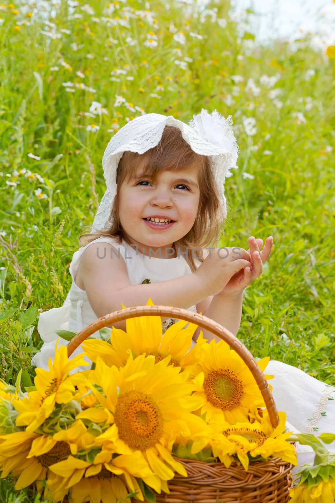 Little girl with a big wattled basket with sunflowers
