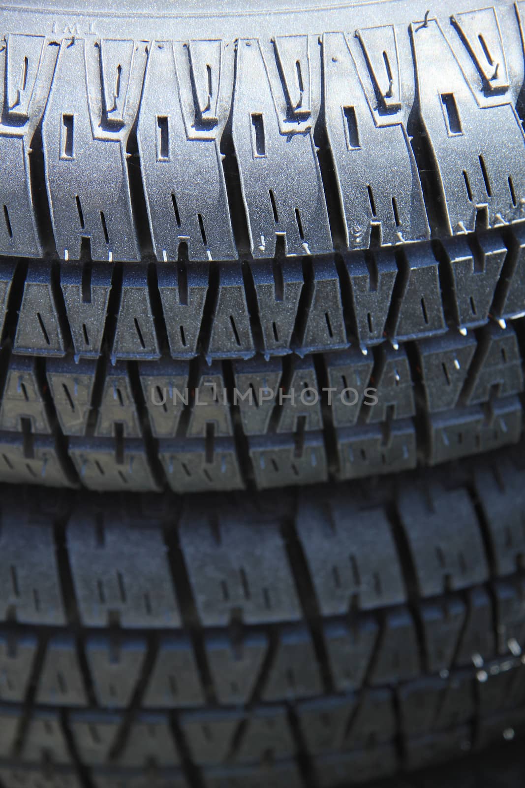 Stacked car tires by studioportosabbia