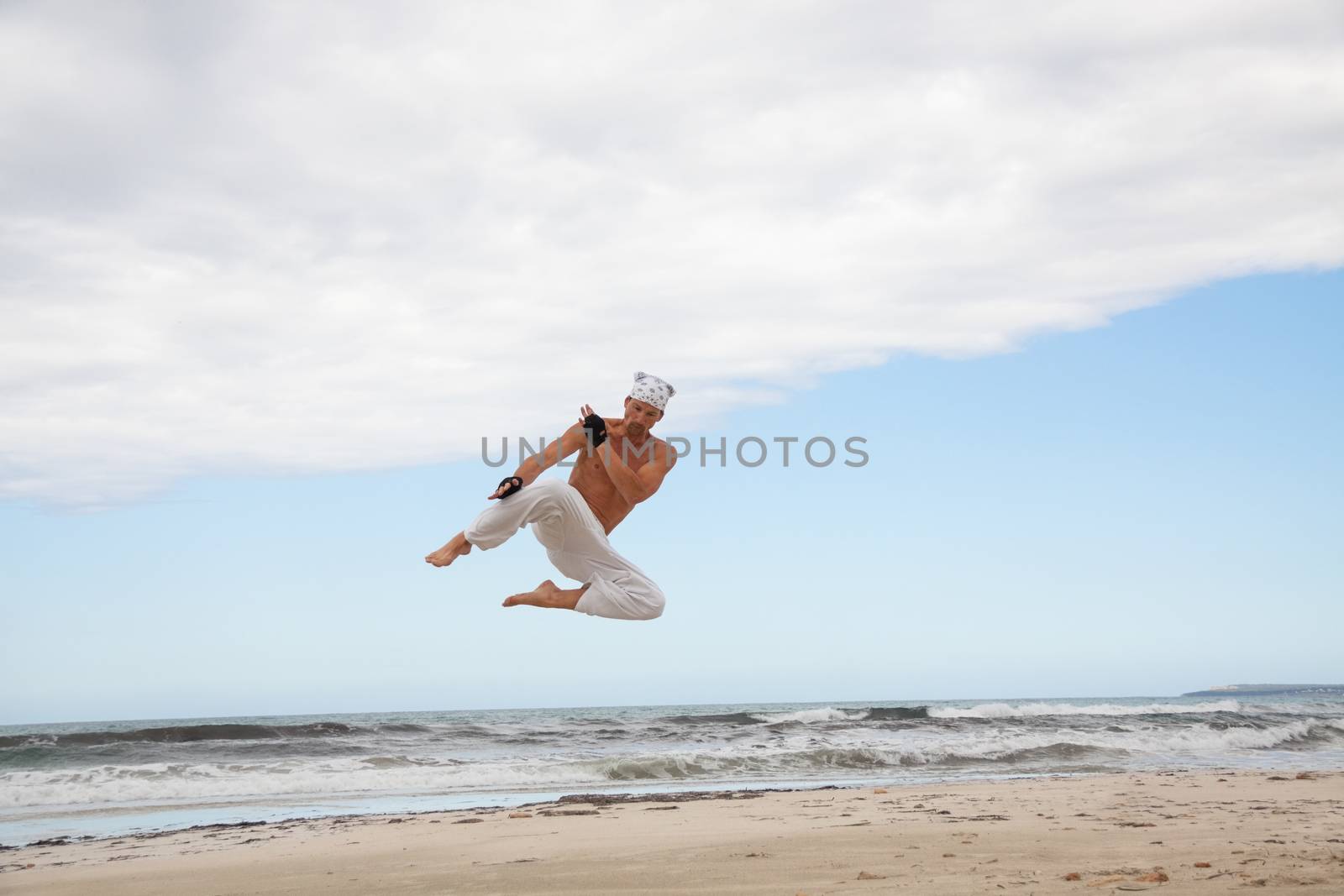 man is jumping sport karate martial arts fight kick jump beach summertime