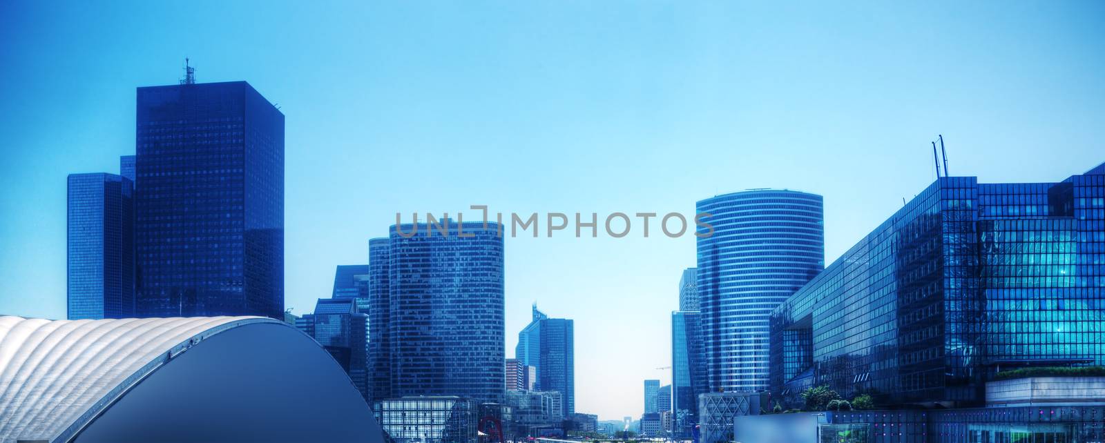 Business skyscrapers panorama in blue tint. La Defense financial district in Paris, France.